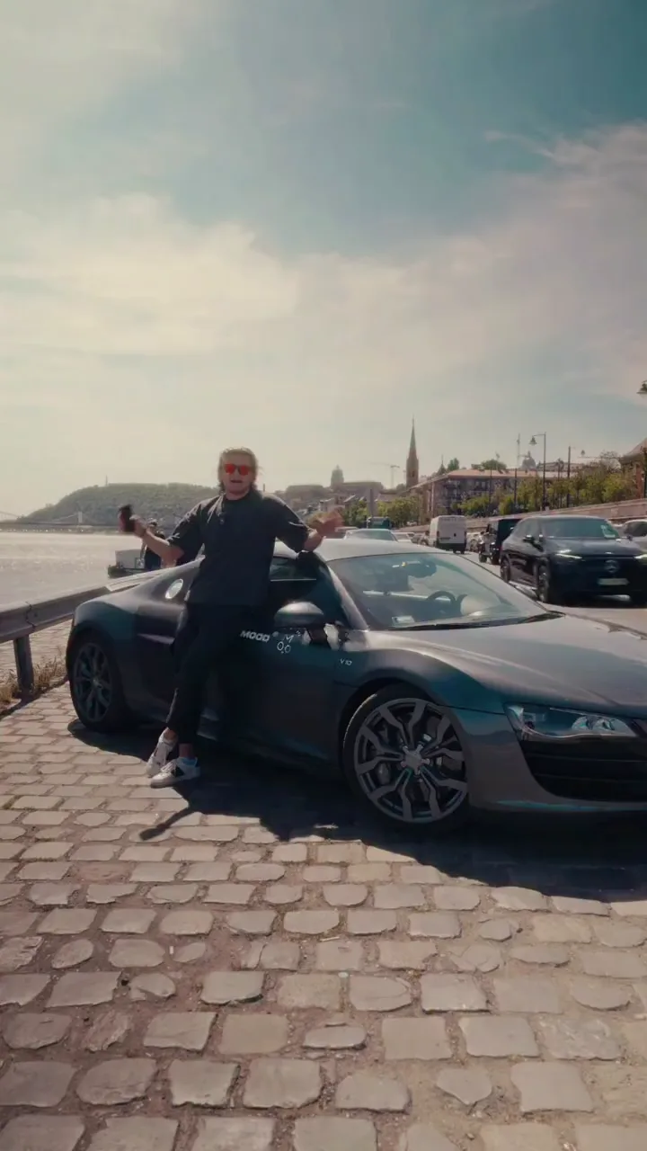 Marci egy Audi R8 mellett a Duna-parton, felirat: lejárt a lízing